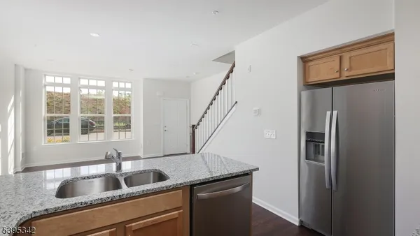 a kitchen with stainless steel appliances granite countertop a refrigerator and a sink