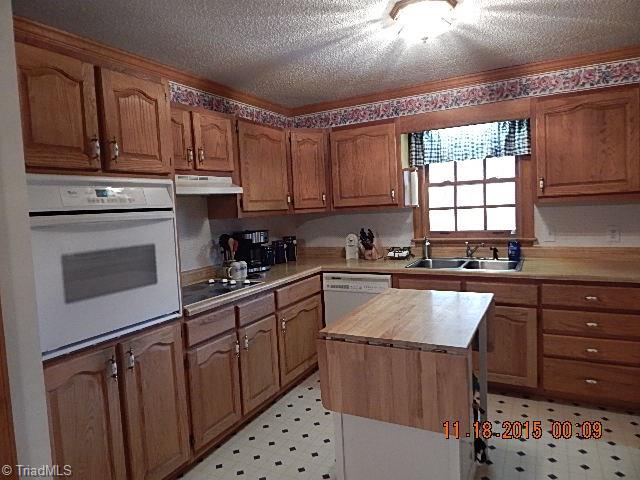 1077 Slate Road King, NC 27021 - Photo 2 of 30 Great kitchen offers built-in oven, cooktop, island, and pantry.