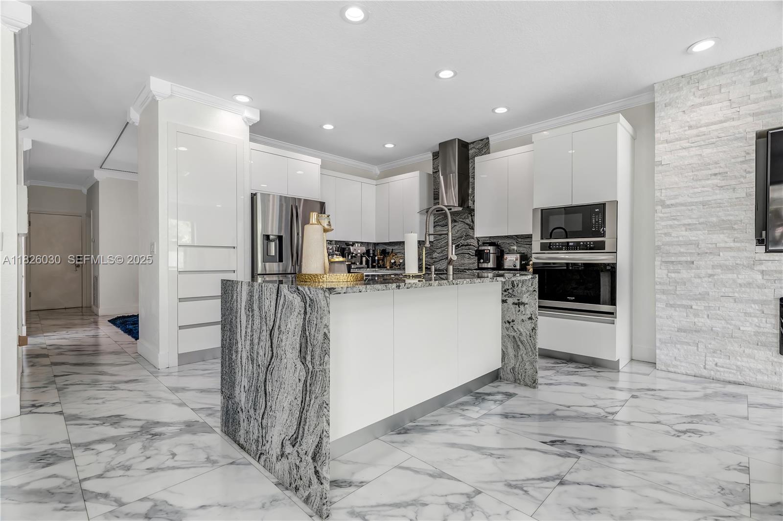 16488 Southwest 30th Street Miramar, FL 33027 - Photo 16 of 50 a kitchen with stainless steel appliances kitchen island granite countertop a refrigerator and a stove top oven
