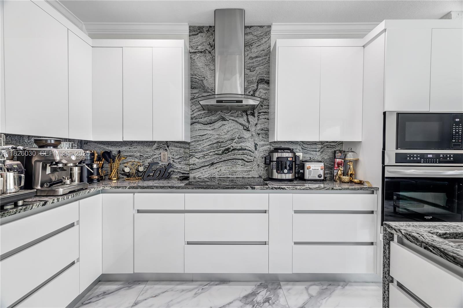 16488 Southwest 30th Street Miramar, FL 33027 - Photo 18 of 50 a kitchen with stainless steel appliances granite countertop a sink a stove and a microwave