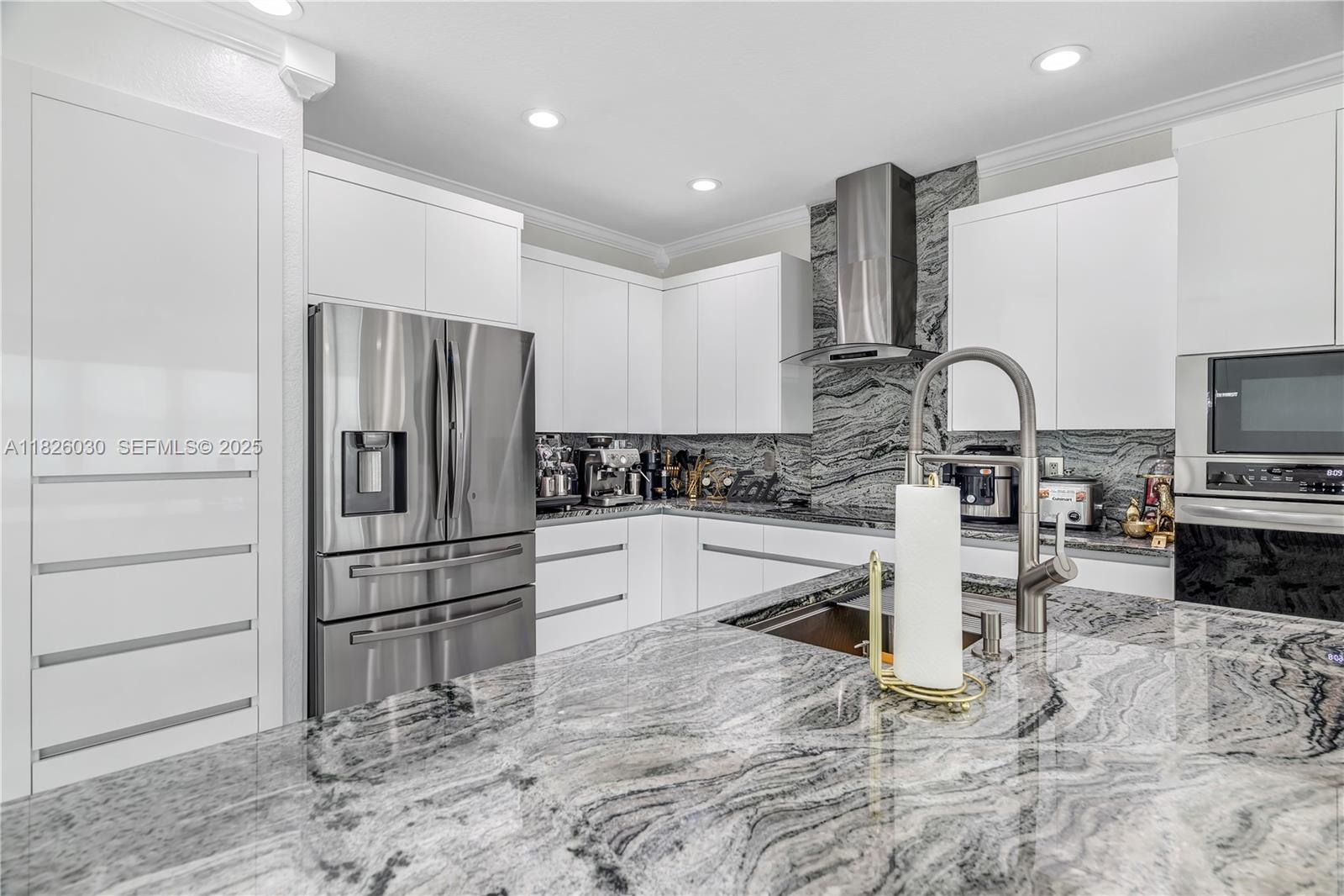 16488 Southwest 30th Street Miramar, FL 33027 - Photo 19 of 50 a kitchen with granite countertop a refrigerator and a stove top oven