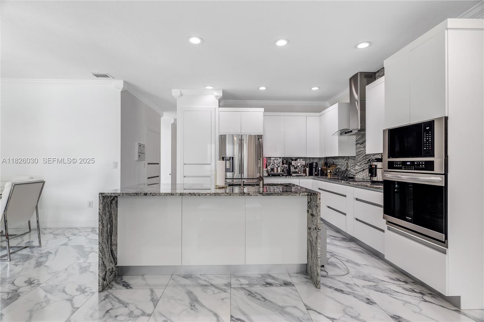 16488 Southwest 30th Street Miramar, FL 33027 - Photo 20 of 50 a kitchen with stainless steel appliances a stove a sink and a microwave