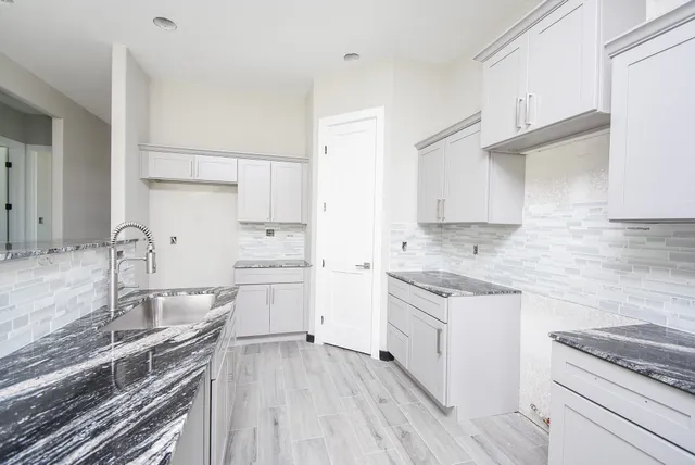 a kitchen with a sink stove top oven and cabinets