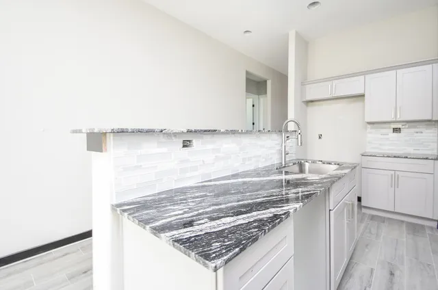a kitchen with a sink stove and cabinets