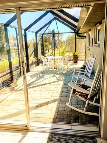 a yellow house with a yard and potted plants