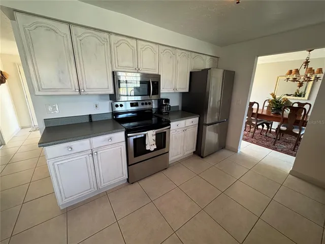 a kitchen with stainless steel appliances granite countertop a refrigerator stove top oven and sink