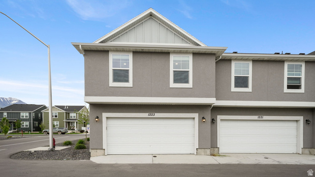 1223 East 1775 North Payson, UT 84651 - Photo 45 of 45 Contemporary townhouse exterior featuring a two-car garage, stucco siding, white trim, and a prominent gable roof
