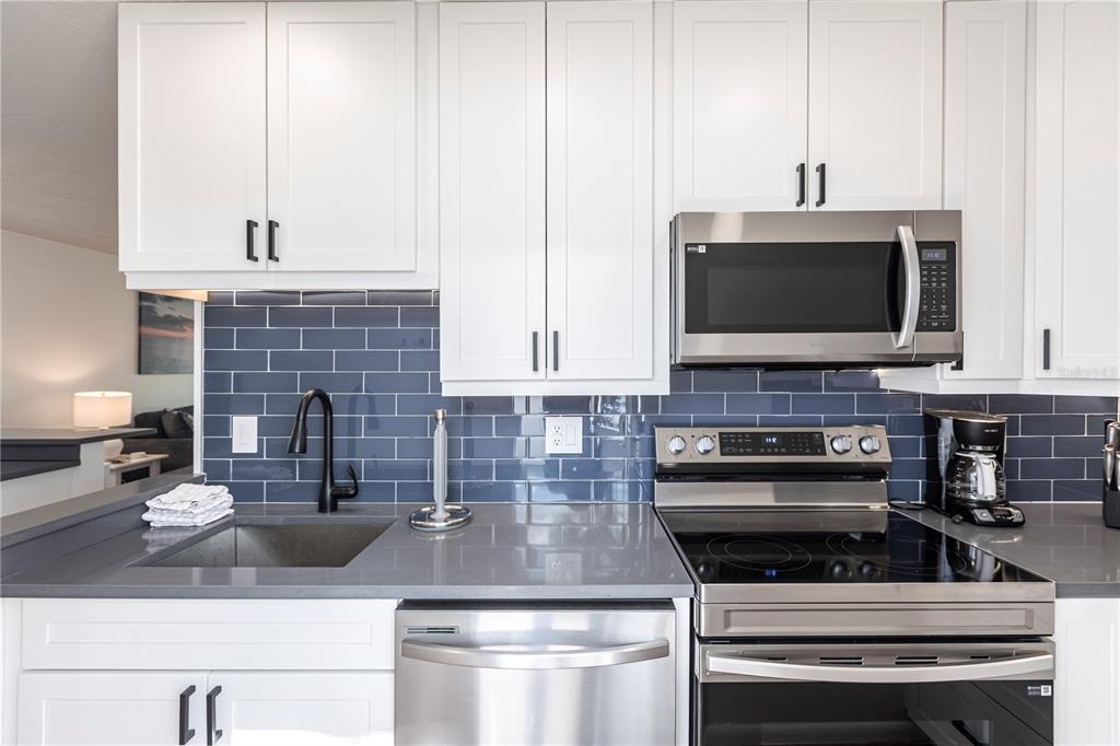 6020 Midnight Pass Road, Unit 48 Sarasota, FL 34242 - Photo 13 of 17 a kitchen with a stove and a microwave