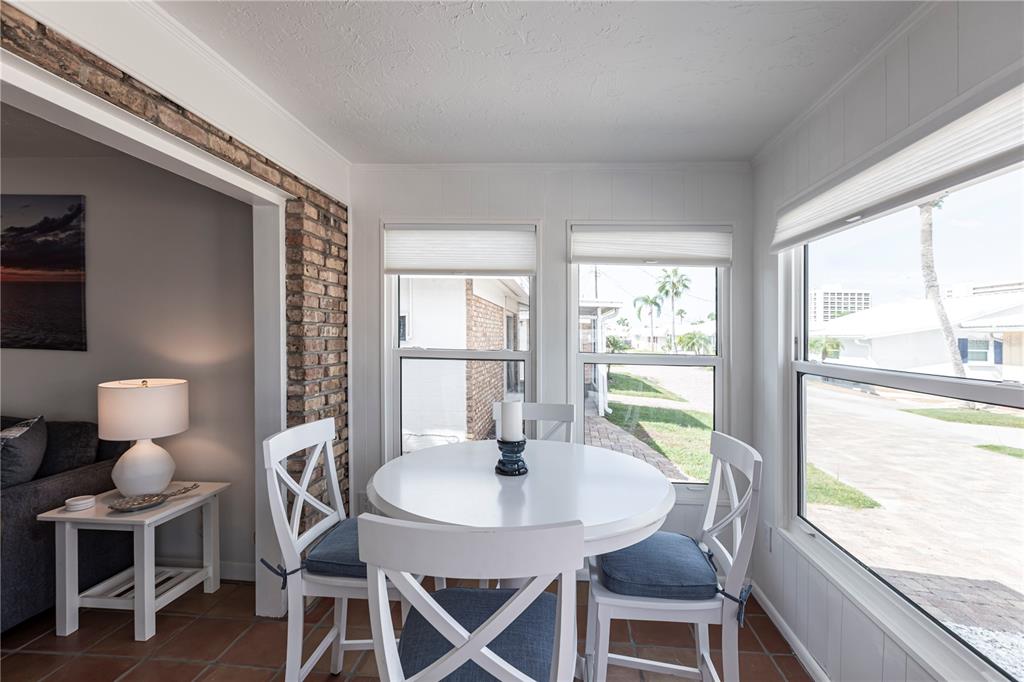 6020 Midnight Pass Road, Unit 48 Sarasota, FL 34242 - Photo 6 of 17 a view of a dining room with furniture a chandelier and a large window