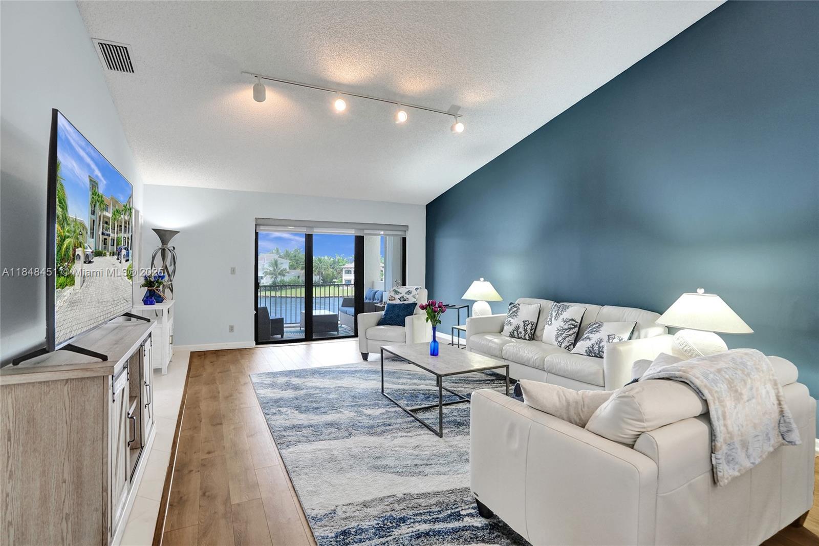 1101 South Riverside Drive, Unit 301 Pompano Beach, FL 33062 - Photo 13 of 40 a living room with furniture and a flat screen tv