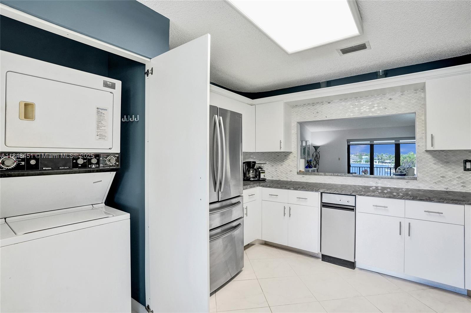 1101 South Riverside Drive, Unit 301 Pompano Beach, FL 33062 - Photo 17 of 40 a kitchen with granite countertop white cabinets and white appliances