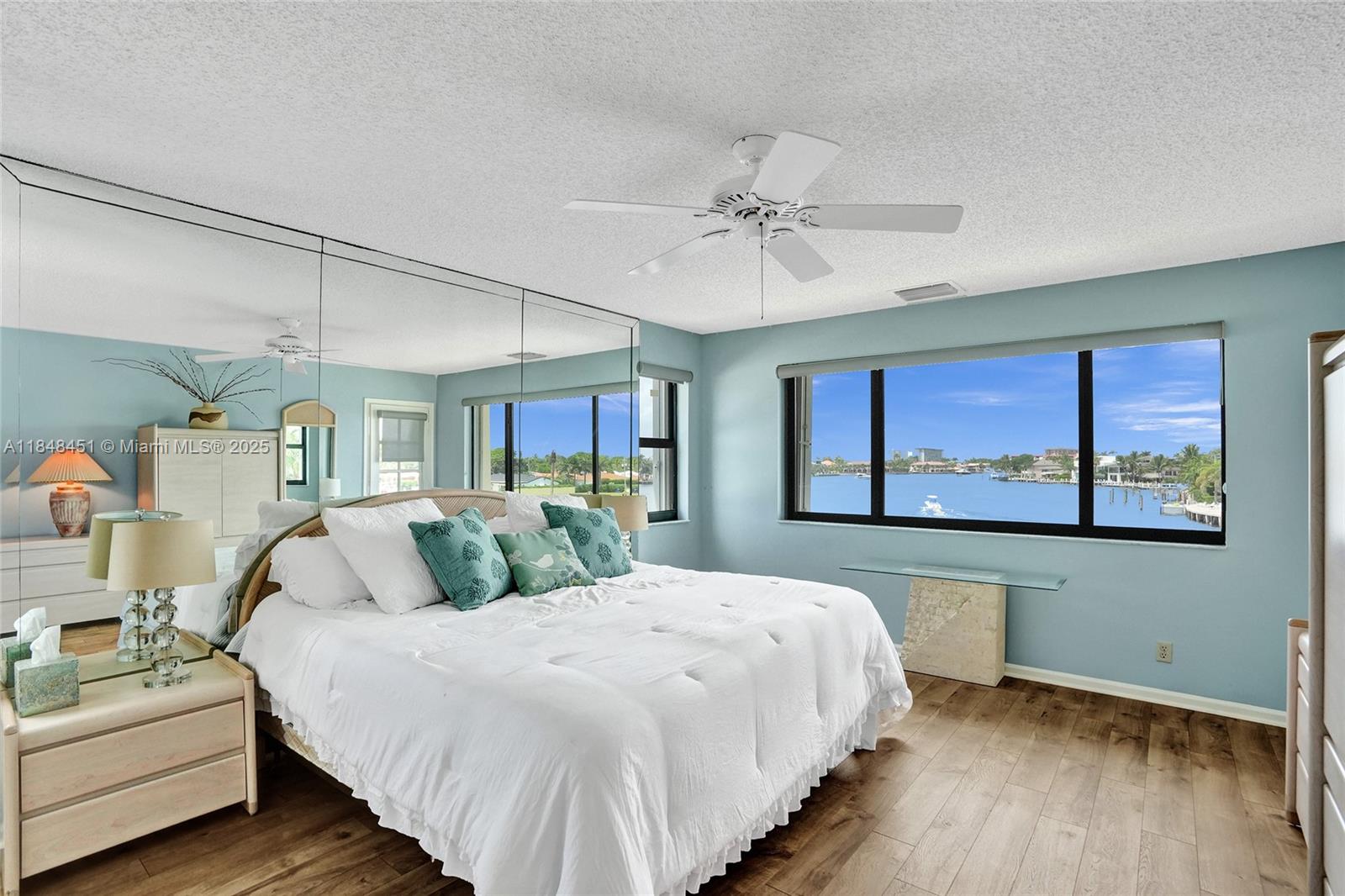 1101 South Riverside Drive, Unit 301 Pompano Beach, FL 33062 - Photo 21 of 40 a bedroom with a large bed and a chandelier