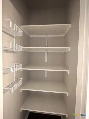a view of walk in closet with empty racks