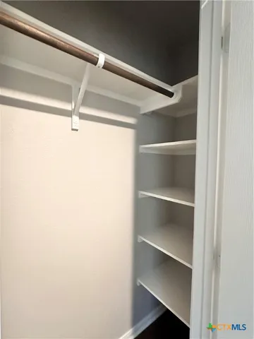 a view of walk in closet with empty racks