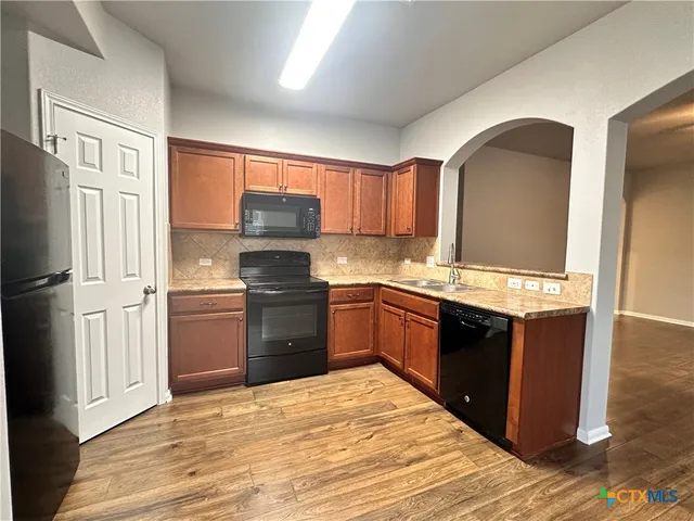 a kitchen with a refrigerator stove and sink