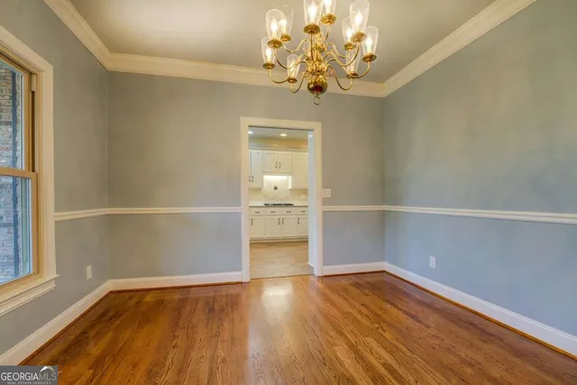 a view of a room with wooden floor and chandelier