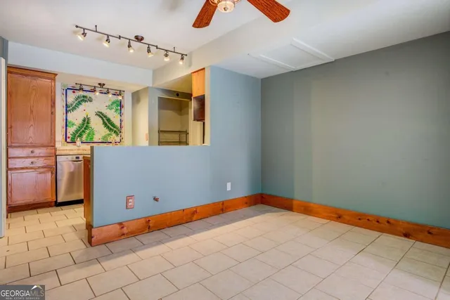 an empty room with chandelier fan and window