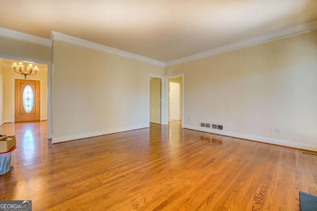 a view of an empty room with wooden floor