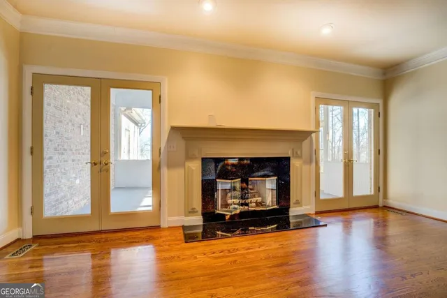 a view of a livingroom with wooden floor and a fireplace