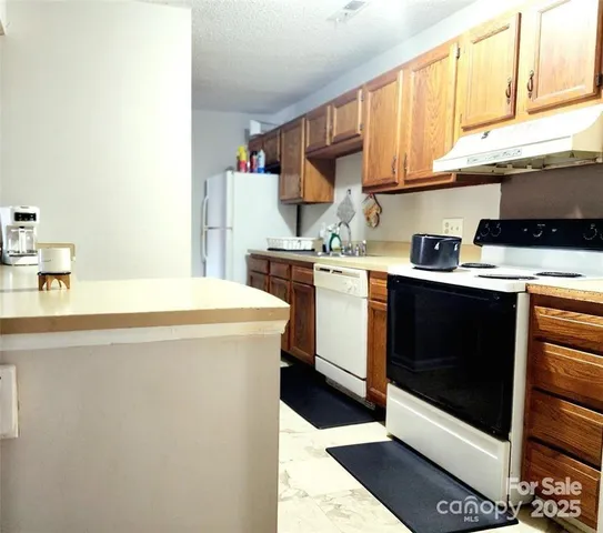 a kitchen with stainless steel appliances a stove a microwave and white cabinets