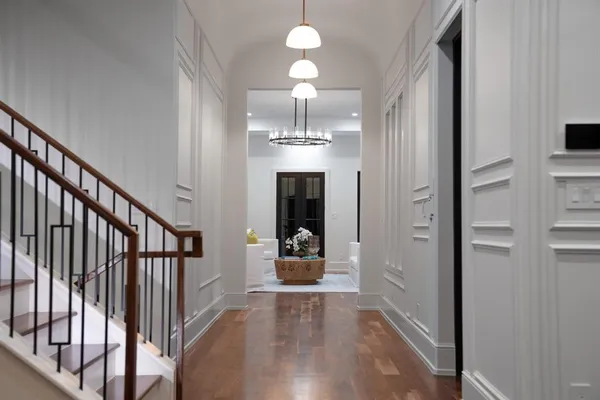 a view of a hallway with wooden floor and staircase