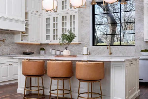 a kitchen with stainless steel appliances granite countertop a table chairs sink and cabinets