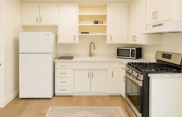 a kitchen with white cabinets and white appliances