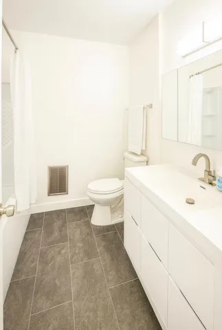 a bathroom with a sink a toilet and mirror