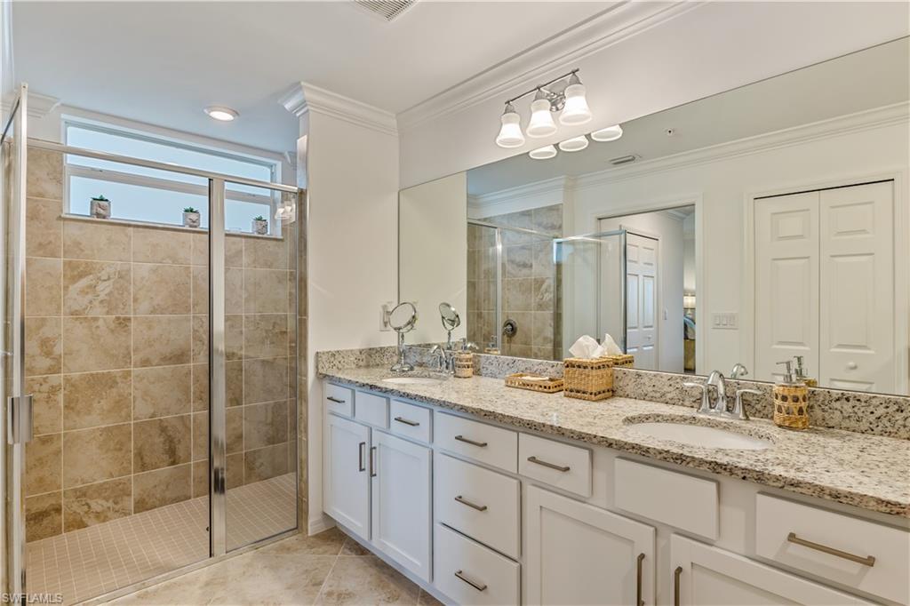 43031 Greenway Boulevard, Unit 1028 Babcock Ranch, FL 33982 - Photo 2 of 15 a bathroom with a granite countertop double vanity sink mirror and shower
