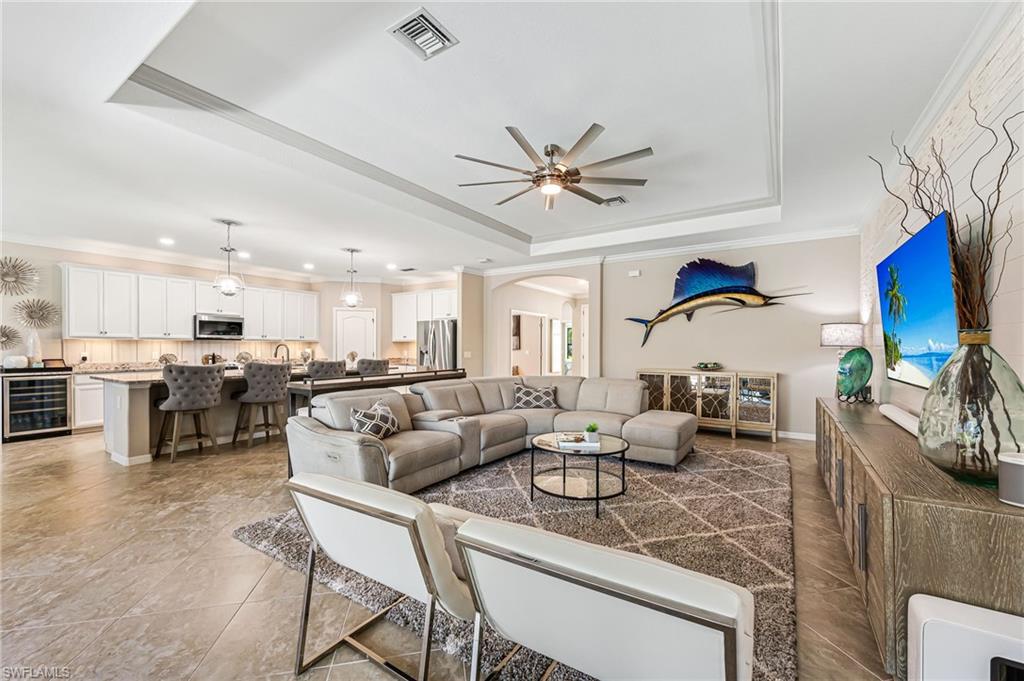 4686 Abaca Circle Naples, FL 34119 - Photo 11 of 47 a living room with furniture kitchen view and a chandelier