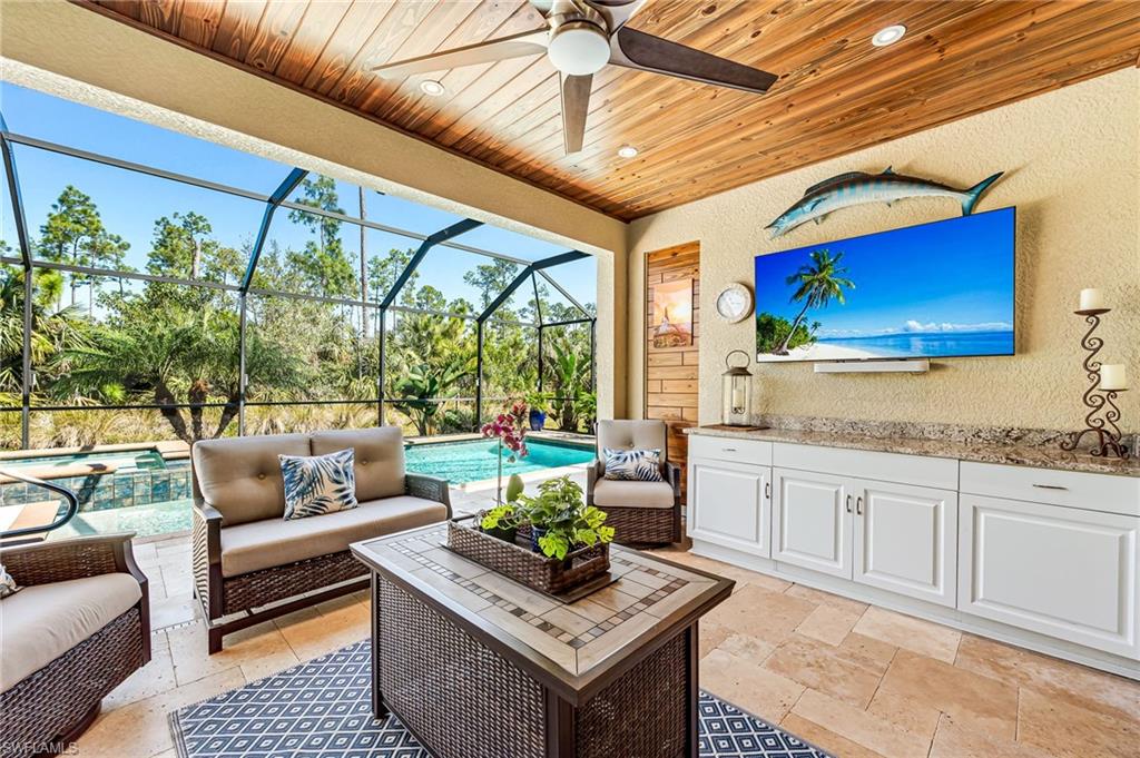 4686 Abaca Circle Naples, FL 34119 - Photo 32 of 47 a living room with patio furniture and a flat screen tv