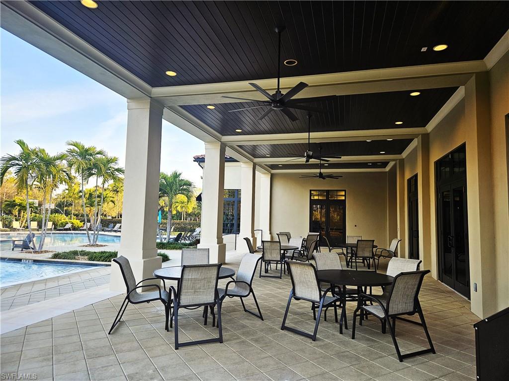 4686 Abaca Circle Naples, FL 34119 - Photo 46 of 47 a view of a porch with dining table and chairs with potted plants