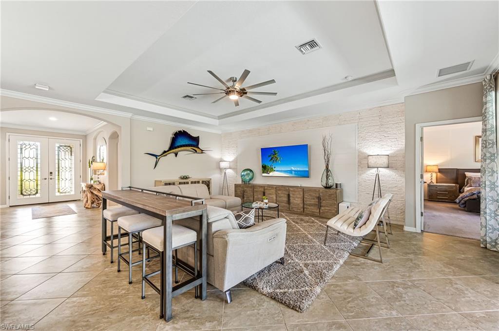 4686 Abaca Circle Naples, FL 34119 - Photo 10 of 47 a living room with furniture a table and a chandelier