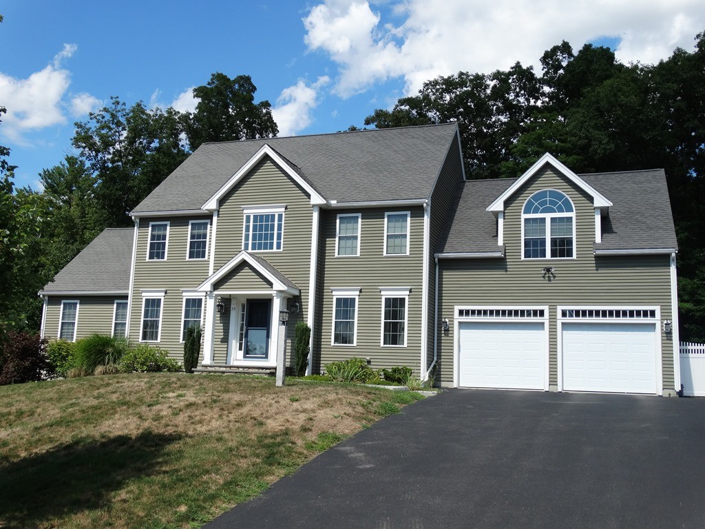 39 Ridgewood Street Ashland, MA 01721 - Photo 1 of 30 a front view of a house with a yard and garage