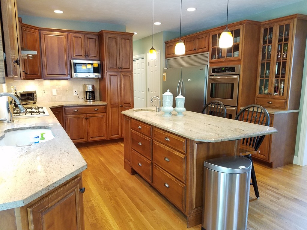 39 Ridgewood Street Ashland, MA 01721 - Photo 4 of 30 a kitchen with a stove a sink a refrigerator and wooden cabinets