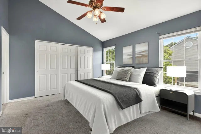 a bedroom with a bed a chandelier and a large window