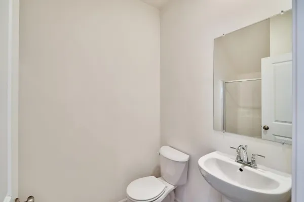 a bathroom with a toilet sink and a mirror