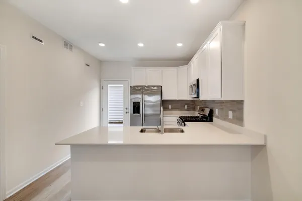 a kitchen with kitchen island a sink appliances and cabinets