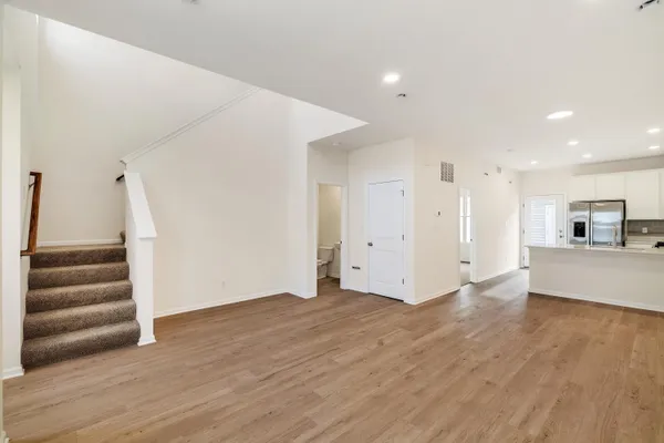a view of empty room with wooden floor and window