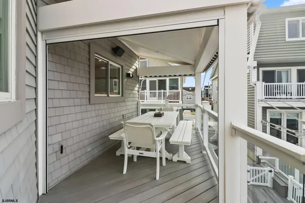 a view of a roof deck with table and chairs a barbeque