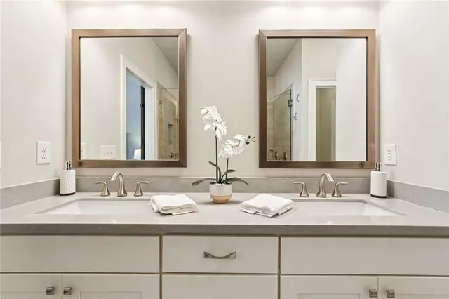 a bathroom with double vanity sinks and a mirror