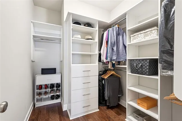 a view of walk in closet with clothes and shoes