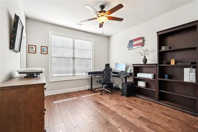 a view of a workspace with furniture and a window