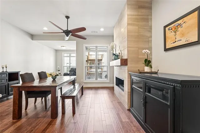 a kitchen with stainless steel appliances granite countertop a stove top oven a sink dishwasher a dining table and chairs with wooden floor