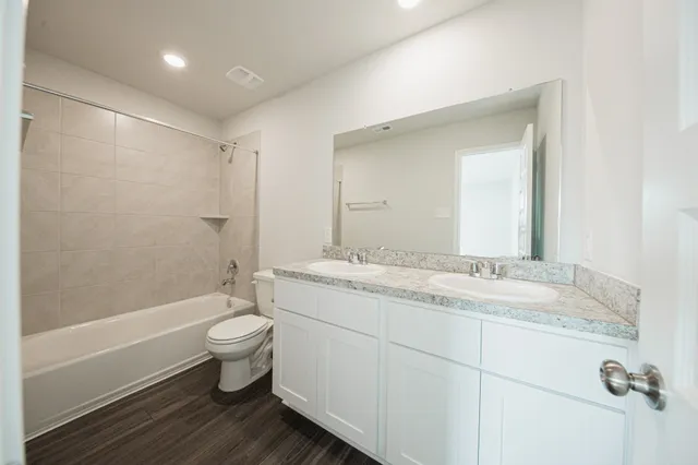 a bathroom with a granite countertop sink toilet and shower
