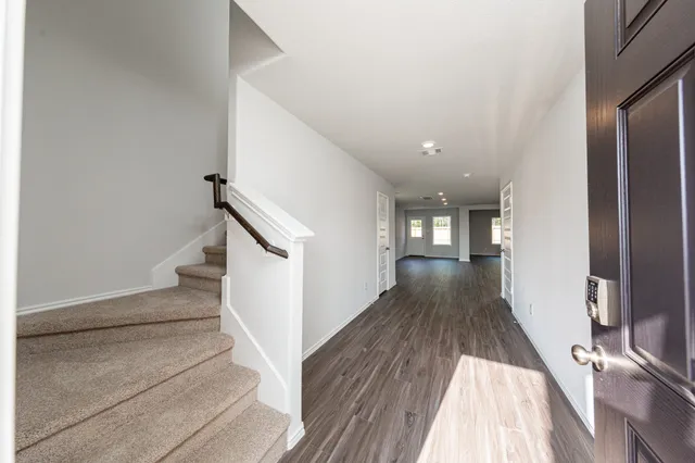 a view of a hallway with wooden floor and staircase