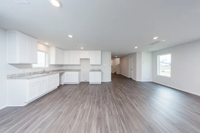 a large kitchen with wooden floors and white stainless steel appliances