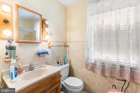 a bathroom with a sink toilet vanity and tub