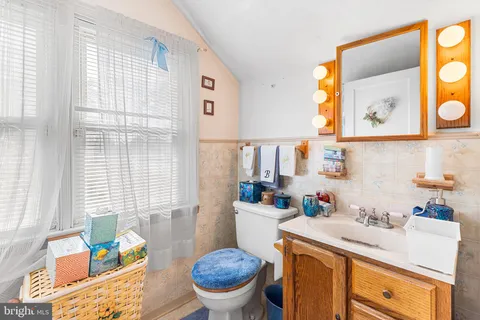 a bathroom with a granite countertop sink mirror and a window