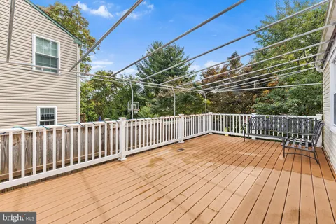 a view of deck with wooden floor and fence with a pot